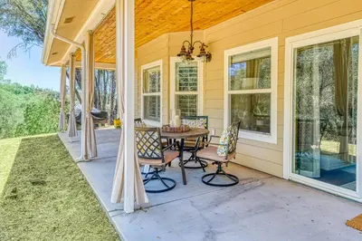 a patio with a table and chairs on a house at Wooded Bliss in Mariposa