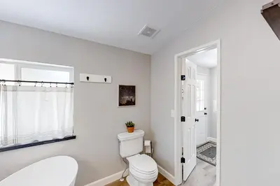 a white bathroom with a toilet and a window at Out in the Wild in Oakhurst