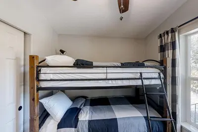 two bunk beds in a room with a window at Out in the Wild in Oakhurst