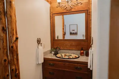 a bathroom with a sink and a mirror at Scenic View Timber Lodge HotTub by Casa Oso in Mariposa