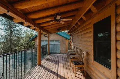a wooden deck with chairs and a ceiling fan at Scenic View Timber Lodge HotTub by Casa Oso in Mariposa