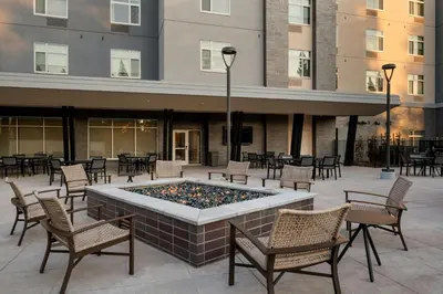 a pool with chairs and tables in front of a building at TownePlace Suites by Marriott Sacramento Rancho Cordova in Rancho Cordova