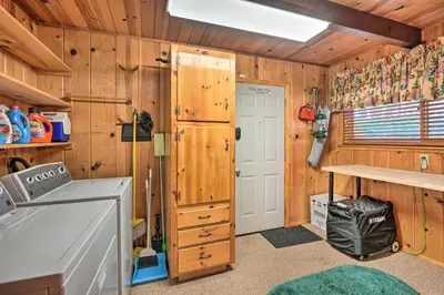 a kitchen with wooden walls and a door and a counter at Comfortable Mi-Wuk Village Cabin Hike and Ski! in Mi-Wuk Village