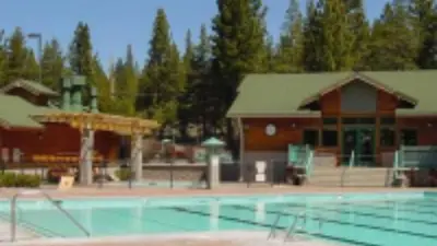 a large swimming pool in front of a building at Whiskey Springs by AvantStay Classic Cabin Near Tahoe Donner Ski Area in Truckee