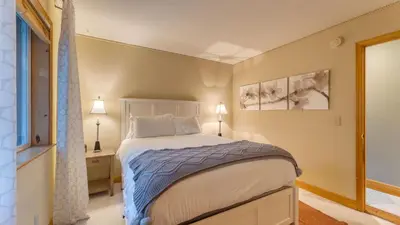 a bedroom with a large bed and two lamps at Golden Summit by AvantStay Stunning Secluded Cabin w Access to Tahoe Donner in Truckee