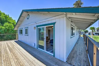 a small white house with a large deck at Waterfront Bethel Island Home with Dock and Slip in Bethel Island