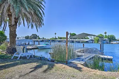 a dock with chairs and a boat in the water at Waterfront Bethel Island Home with Dock and Slip in Bethel Island
