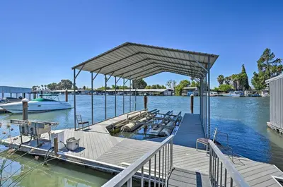 a wooden dock with a boat on the water at Waterfront Bethel Island Home with Dock and Slip in Bethel Island