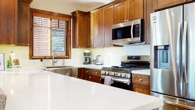 a kitchen with wooden cabinets and a stainless steel refrigerator at Lakeview Townhomes #5 townhouse in Mammoth Lakes
