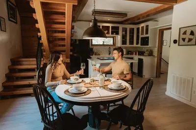 a man and woman sitting at a table with wine glasses at Romantic Forest Lovers Nest by Casa Oso in Mariposa