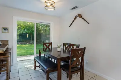a dining room with a table and chairs and a window at Acorn House - Charming house in green heaven with pool table with lovely backyard in Oakhurst