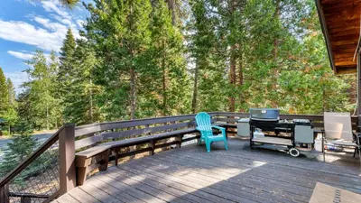 a blue chair sitting on a deck with a desk at Ember by AvantStay Majestic Entertainers Home w Pine Tree Views Close to Meeks Bay in Tahoma Meadows