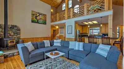 a living room with a blue couch and a fireplace at Black Bear by AvantStay Spacious Viking Lodge in Tahoe Donner w Game Room Hot Tub in Truckee