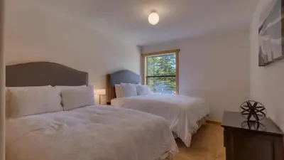 a bedroom with two beds and a window at Black Bear by AvantStay Spacious Viking Lodge in Tahoe Donner w Game Room Hot Tub in Truckee