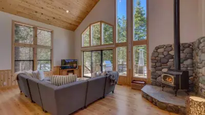 a living room with a couch and a fireplace at Black Bear by AvantStay Spacious Viking Lodge in Tahoe Donner w Game Room Hot Tub in Truckee