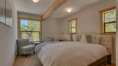 a bedroom with a large bed and a chair at Black Bear by AvantStay Spacious Viking Lodge in Tahoe Donner w Game Room Hot Tub in Truckee