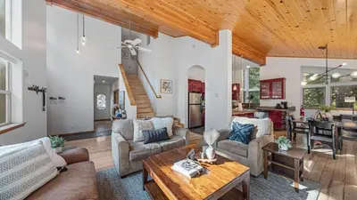 a living room filled with furniture and a wooden ceiling at Moosetrack by AvantStay Cozy Cabin w Hot Tub In The Heart of Tahoe Donner in Truckee