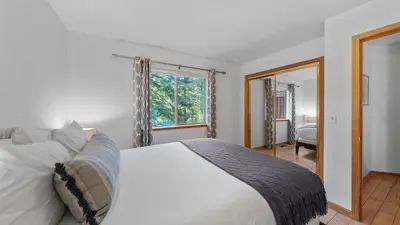 a bedroom with a white bed and a window at Moosetrack by AvantStay Cozy Cabin w Hot Tub In The Heart of Tahoe Donner in Truckee