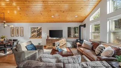 a living room with leather furniture and a wooden ceiling at Moosetrack by AvantStay Cozy Cabin w Hot Tub In The Heart of Tahoe Donner in Truckee