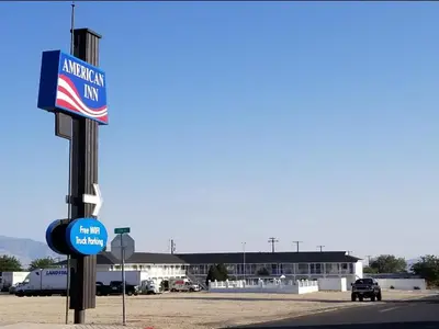 an american inn sign in front of a parking lot at American Inn in Hawthorne