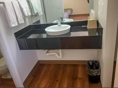 a bathroom with a sink and a mirror at American Inn in Hawthorne