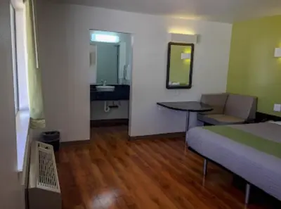 a bedroom with a bed and a table and a sink at American Inn in Hawthorne