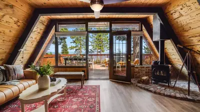 a living room with a couch and a fireplace at Horizon by AvantStay Stunning A-frame Cabin w Hot Tub Billiards Lake Views in Tahoe City