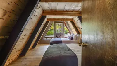 two beds in a room with an attic at Horizon by AvantStay Stunning A-frame Cabin w Hot Tub Billiards Lake Views in Tahoe City