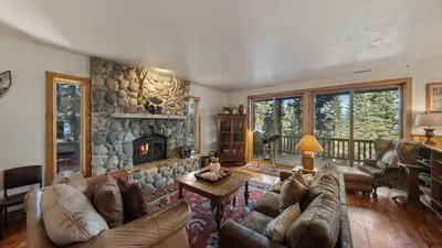 a living room with a couch and a stone fireplace at Ellis Peak by AvantStay Beautiful McKinney Cabin w Filtered Lake Views in Homewood