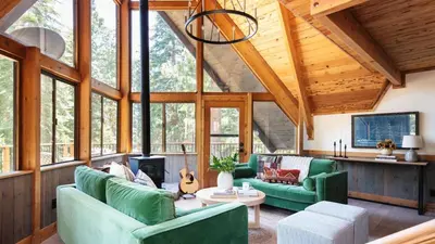a living room with green furniture in a wooden house at Timberline by AvantStay Stunning Chalet Cabin w Hot Tub Pool Table Home Theater in Tahoe Vista
