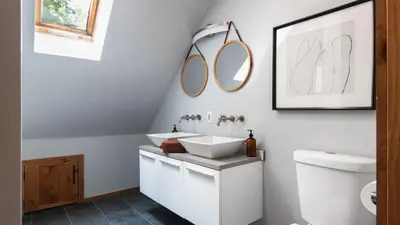 a bathroom with a sink and two mirrors on the wall at Timberline by AvantStay Stunning Chalet Cabin w Hot Tub Pool Table Home Theater in Tahoe Vista