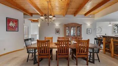 a dining room with a wooden table and chairs at Sparrow by AvantStay Modern Mountain Retreat w Hot Tub Pool Table Games in Truckee
