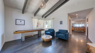 a living room with a piano and two blue chairs at Lakeview by AvantStay Private Waterfront Cabin on Lake Tahoe w Hot Tub Views in Tahoe Vista