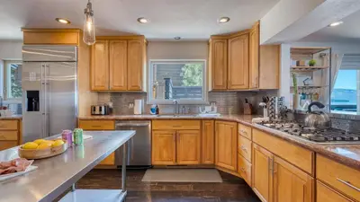 a kitchen with wooden cabinets and stainless steel appliances at Lakeview by AvantStay Private Waterfront Cabin on Lake Tahoe w Hot Tub Views in Tahoe Vista