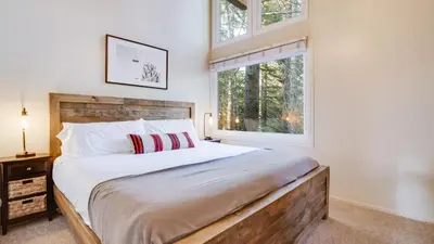 a bedroom with a large bed and a window at Hot Tub Sauna Game Room Modern 5BDR Family Cabin Homewood by AvantStay in Tahoma Meadows