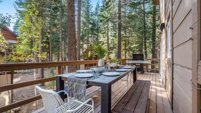 a wooden deck with a table and chairs on it at Hot Tub Sauna Game Room Modern 5BDR Family Cabin Homewood by AvantStay in Tahoma Meadows