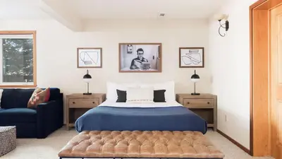 a bedroom with a blue bed and a blue couch at Redwood by AvantStay Secluded Cabin w Views Spa 5mins to NorthStar in Ponderosa Fairway Estates