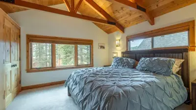 a bedroom with a bed and two windows at Henderson by AvantStay Lake View Walk to Beach Garwoods More in Carnelian Bay