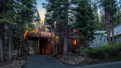 a house in the woods with a tree at Wolfe by AvantStay 5mins NorthStar Fireplace 2 Private Decks in Ponderosa Fairway Estates