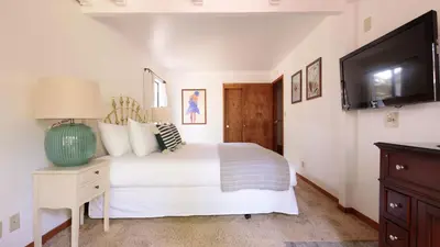 a bedroom with a white bed and a flat screen tv at Wolfe by AvantStay 5mins NorthStar Fireplace 2 Private Decks in Ponderosa Fairway Estates