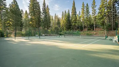 a tennis court with two tennis rackets on it at Wolfe by AvantStay 5mins NorthStar Fireplace 2 Private Decks in Ponderosa Fairway Estates