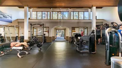 a gym with tread machines and a woman laying on the floor at Wolfe by AvantStay 5mins NorthStar Fireplace 2 Private Decks in Ponderosa Fairway Estates