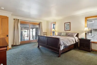 a bedroom with a large bed and a window at Dos Pinos Spacious Lakefront Cabin with Game Room in Groveland