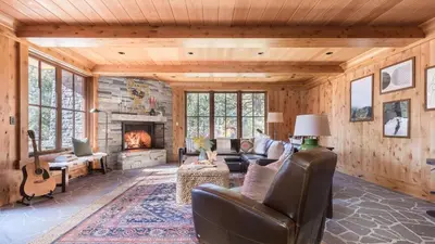 a living room with a couch and a fireplace at Hunter by AvantStay Award-Winning Riverfront Cabin 5 Minutes from Palisades in Olympic Valley