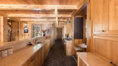 a large kitchen with wooden walls and wooden counters at Hunter by AvantStay Award-Winning Riverfront Cabin 5 Minutes from Palisades in Olympic Valley