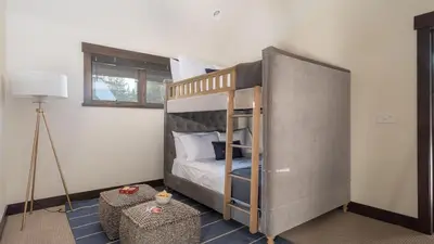 a bedroom with a bunk bed and a lamp at Modern Mountain Home w Cozy Fire Pit 15 Mins frm Northstar Maple by AvantStay in Ponderosa Fairway Estates