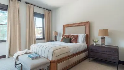 a bedroom with a bed with a mirror and a chair at Modern Mountain Home w Cozy Fire Pit 15 Mins frm Northstar Maple by AvantStay in Ponderosa Fairway Estates