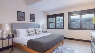 a bedroom with a bed and two windows at Modern Mountain Home w Cozy Fire Pit 15 Mins frm Northstar Maple by AvantStay in Ponderosa Fairway Estates