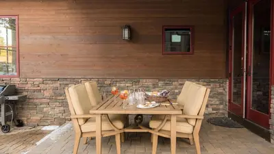 a wooden table with chairs on a patio at Modern Mountain Home w Cozy Fire Pit 15 Mins frm Northstar Maple by AvantStay in Ponderosa Fairway Estates