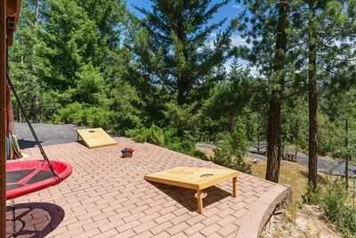 a patio with a wooden table and a picnic table at The Happy Place Mountain View Home in Groveland